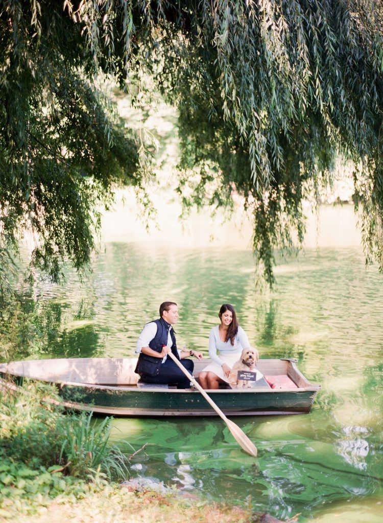A couple in a rowboat with their puppy during romantic NYC engagement photos in Central Park by You Look Lovely