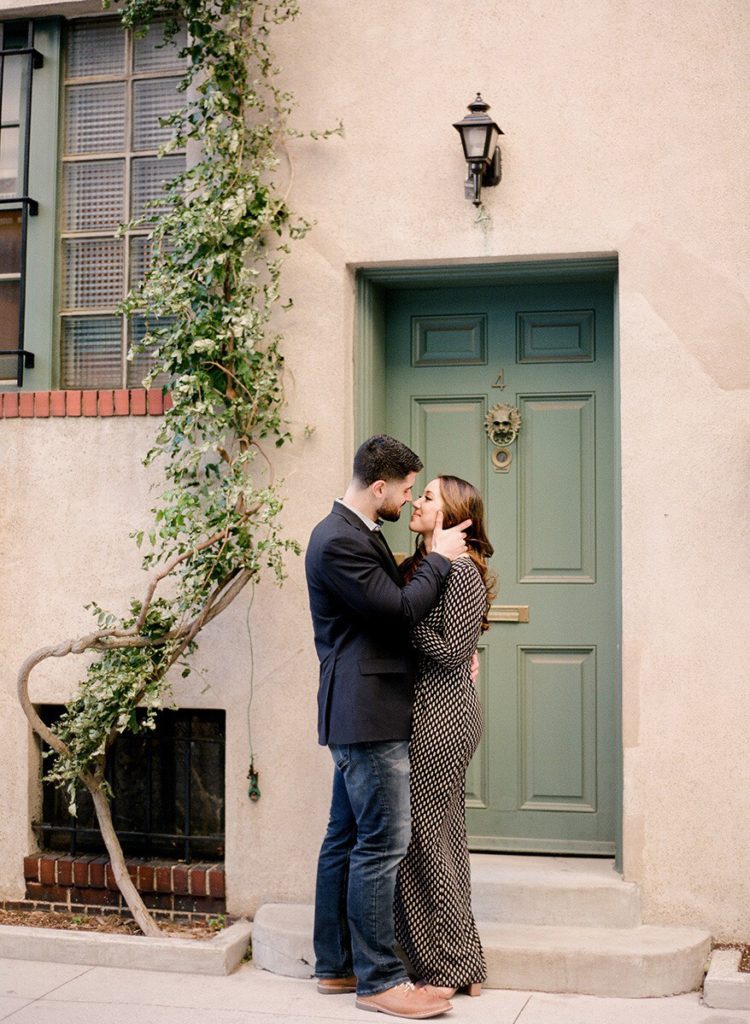 A couple kissing in front of a green door on Washington News during romantic engagement photos in NYC with You Look Lovely Photography
