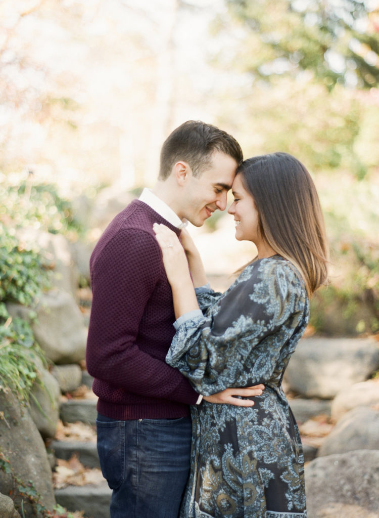 An engaged couple embracing at Brooklyn Botanic Garden during an NYC engagement photo session photographed by You Look Lovely Photography