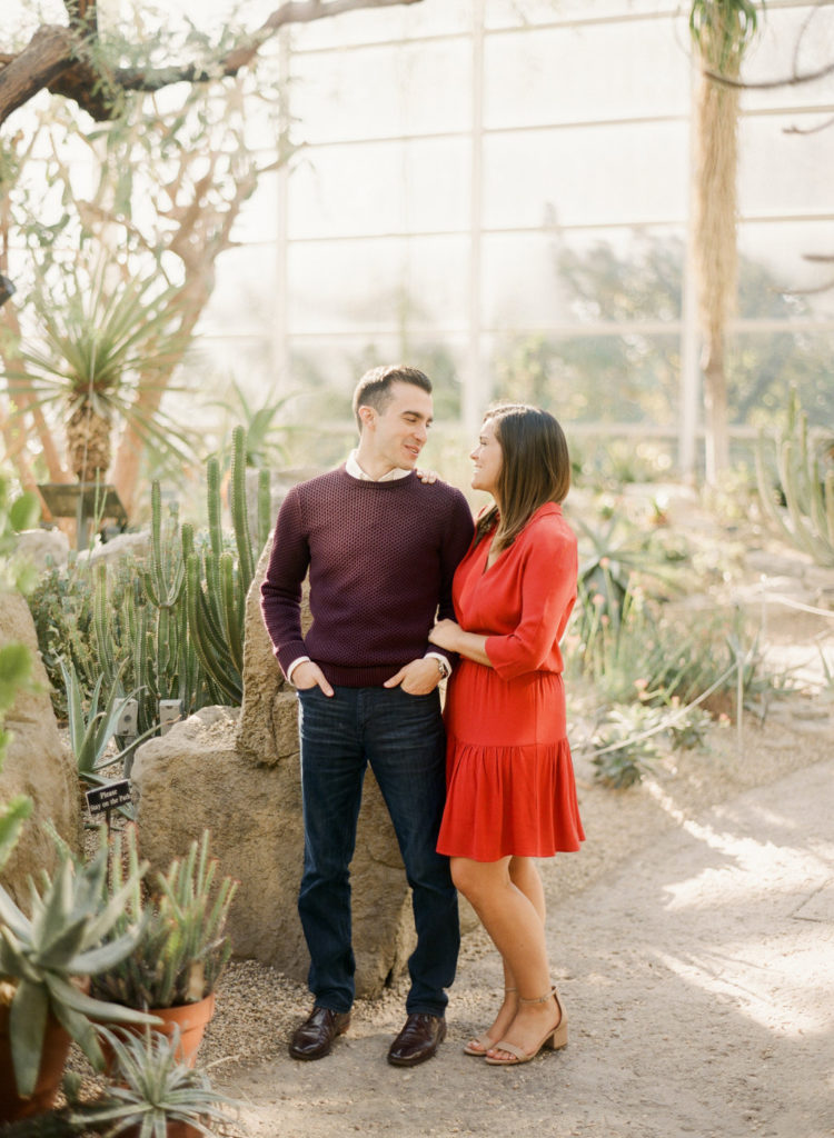 A couple looking at each other inside the Desert Pavilion at Brooklyn Botanic Garden during a romantic New York City engagement photo shoot with You Look Lovely Photography