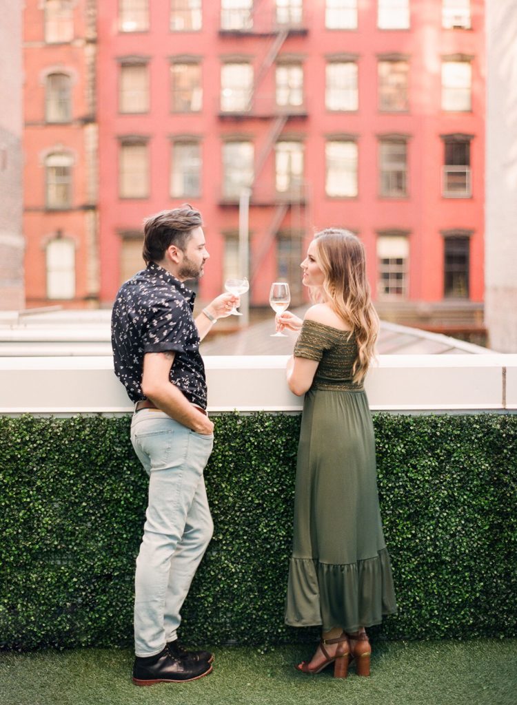 A couple having a glass of wine at NoMo SoHo during romantic NYC engagement photos with You Look Lovely Photography