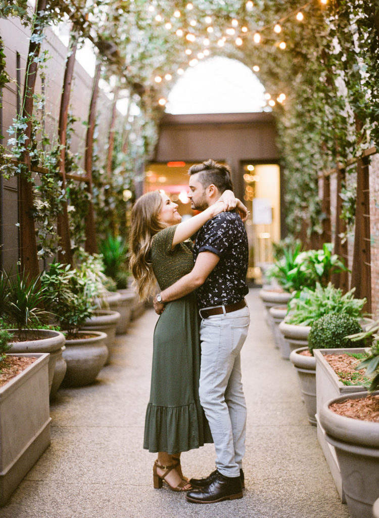 Couple sharing a romantic moment under the archway leading to NoMo during their editorial engagement session with You Look Lovely Photography
