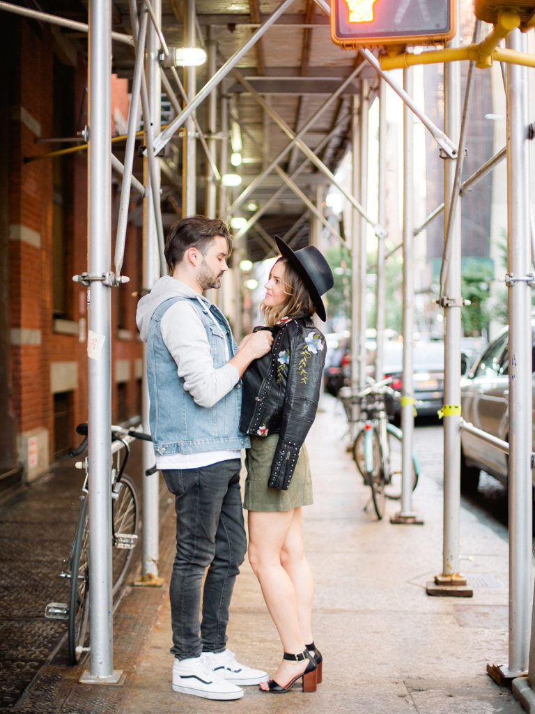A trendy couple get close during their SoHo street engagement photos with You Look Lovely Photography