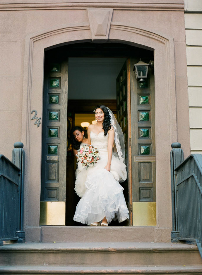 Bride walking out of a NYC brownstone on her way to her wedding photographed by You Look Lovely Photography