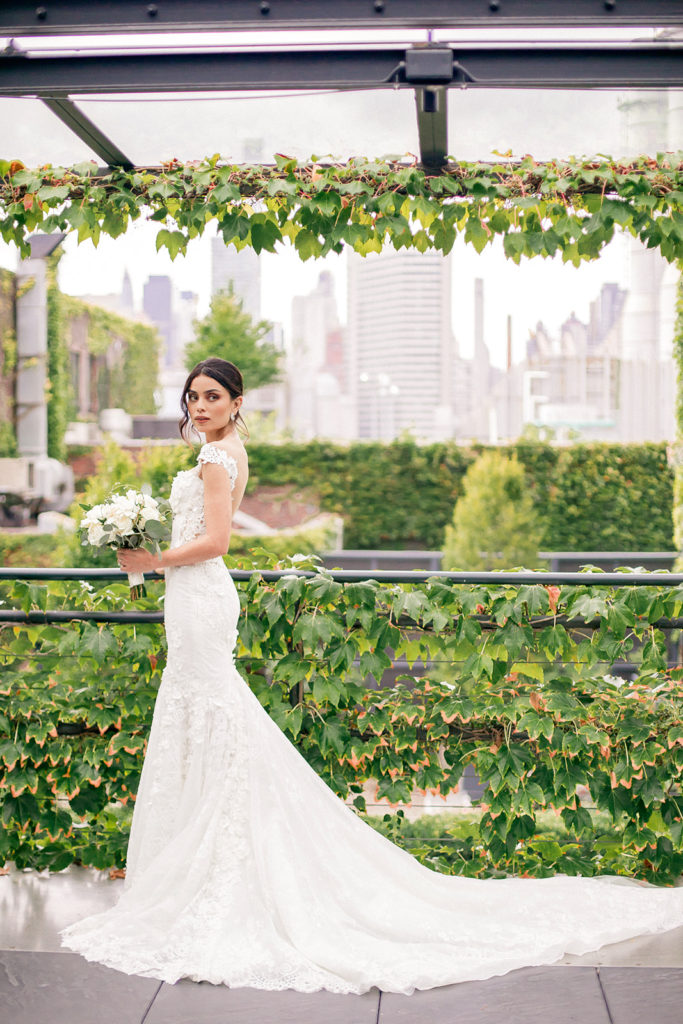 An elegant bride standing on the vine covered balcony for her wedding day at The Foundry NYC photographed by You Look Lovely Photography