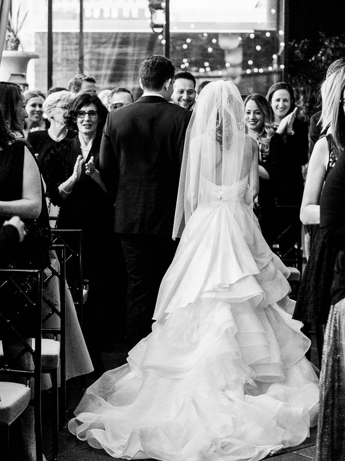 A black and white photo of a bride and groom making their way down the aisle at a Gramercy Park wedding photographed by You Look Lovely Photography