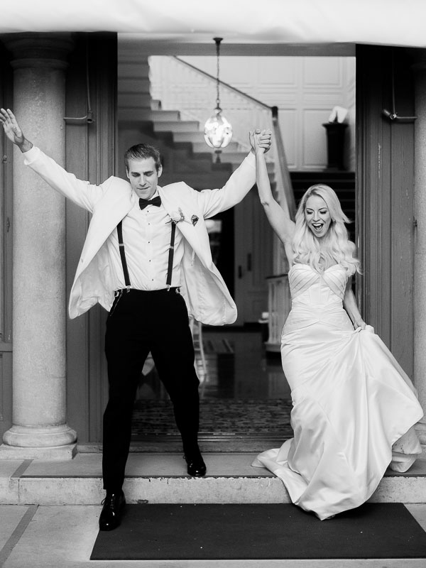 Black and white image of a bride and groom entering their reception at Eolia Mansion in CT photographed by You Look Lovely Photography