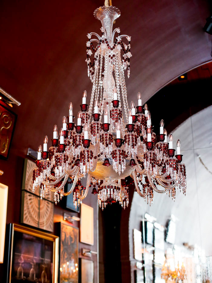 Image of a red and white crystal chandelier inside of the Baccarat Hotel Bar during an NYC wedding photographed by You Look Lovely Photography