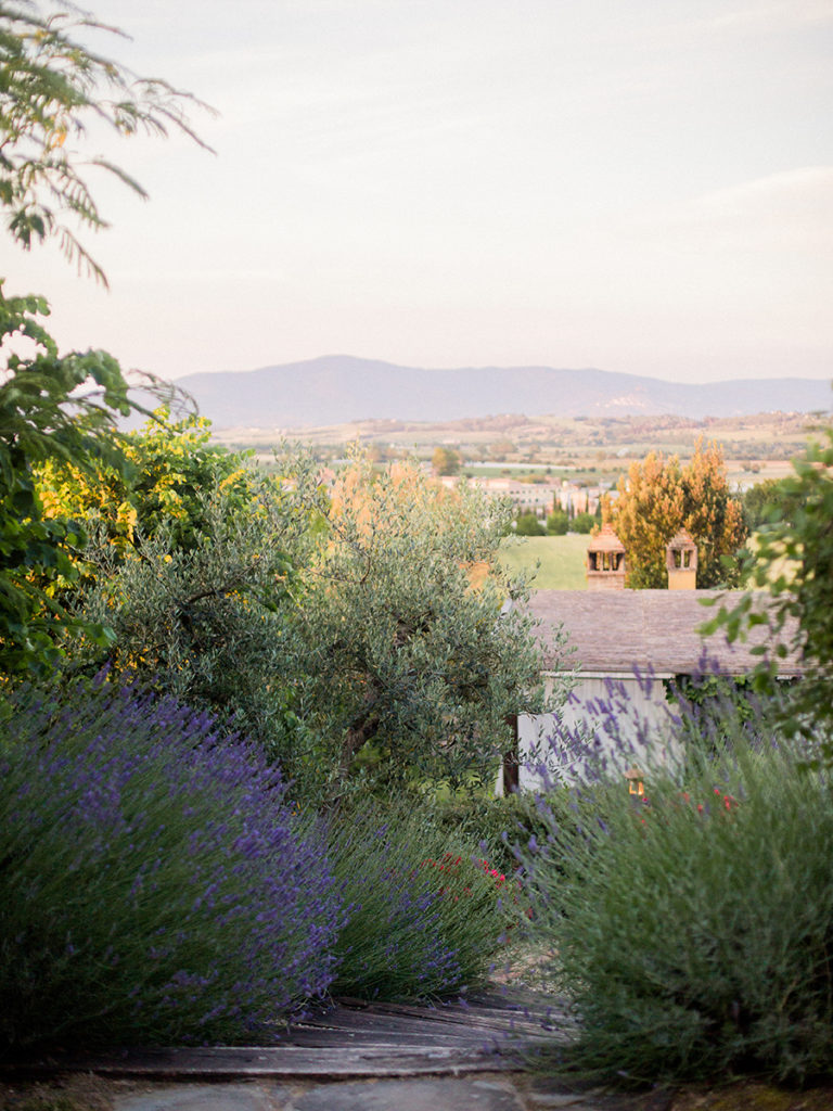 One of the questions to ask a wedding photographer is if they'd be willing to travel for destination weddings, like this scene of a sunset at a villa wedding venue surrounded by lavender in Tuscany, photographed by You Look Lovely Photography