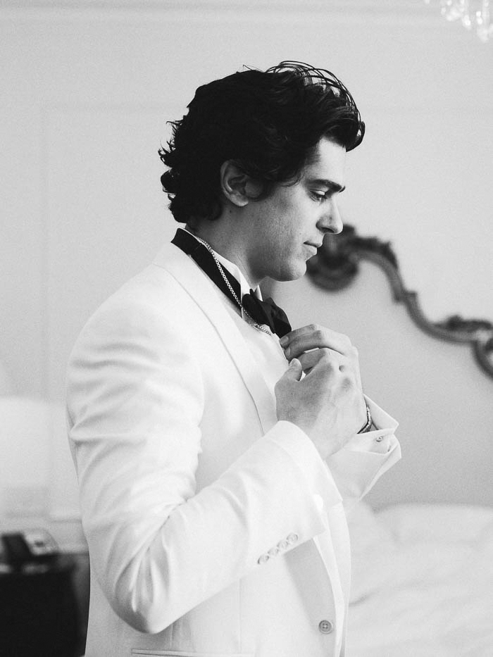 A black and white image of a groom getting ready at the Plaza Hotel in NYC photographed by You Look Lovely Photography